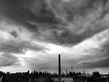 Buildings in city against cloudy sky