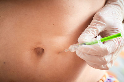 Midsection of woman holding syringe