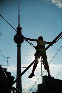 Rear view of boy on bungee trampoline with fernsehturm in background