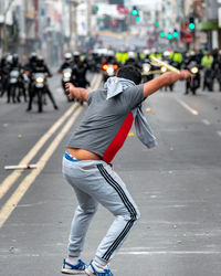 Rear view of man walking on road in city