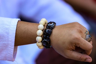 Close-up of man holding hands against blurred background 