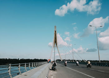 Vehicles on road against sky in city