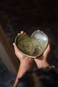 Child holding love yourself ceramic heart