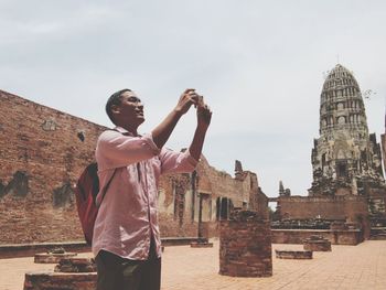 Full length of man standing at historic building against sky