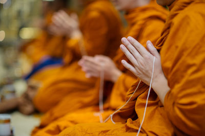 Midsection of monk sitting at temple