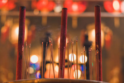 Close-up of burning incense sticks in temple at night