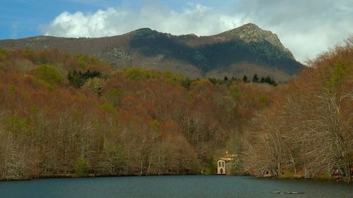 Scenic view of lake by mountain against sky