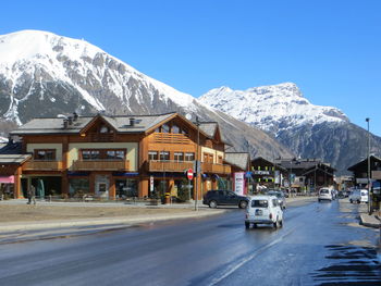 Vehicles on road along built structures