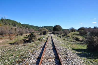 Railroad tracks on field against sky