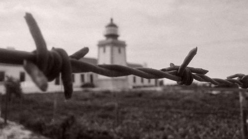 Close-up of barbed wire against sky