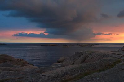 Scenic view of sea against dramatic sky during sunset