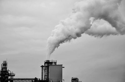 Smoke emitting from chimney against sky