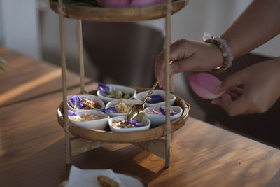 Cropped hand of person preparing food on table