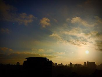 Silhouette buildings against sky at sunset