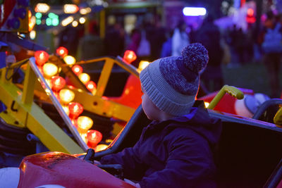 Rear view of child sitting on fairground ride