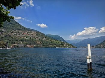 Scenic view of sea and mountains against blue sky