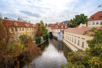 Canal amidst buildings in town against sky