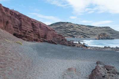 Scenic view of rocky mountains and sea against sky