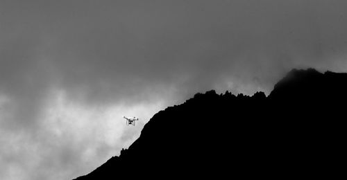 Low angle view of silhouette bird flying against sky