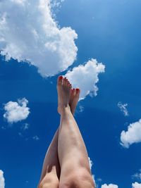 Low section of woman against blue sky