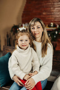 Portrait of smiling young woman sitting at home