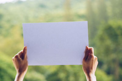 Close-up of hand holding paper outdoors