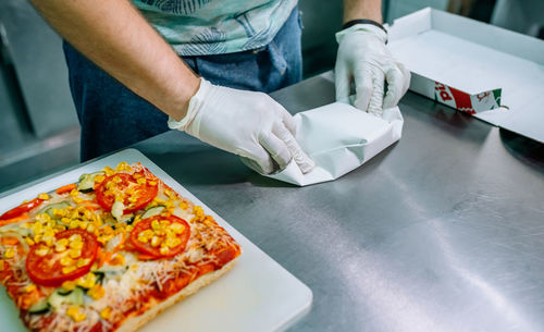 Midsection of man working on table in restaurant
