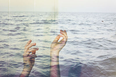 Double exposure of hands and sea
