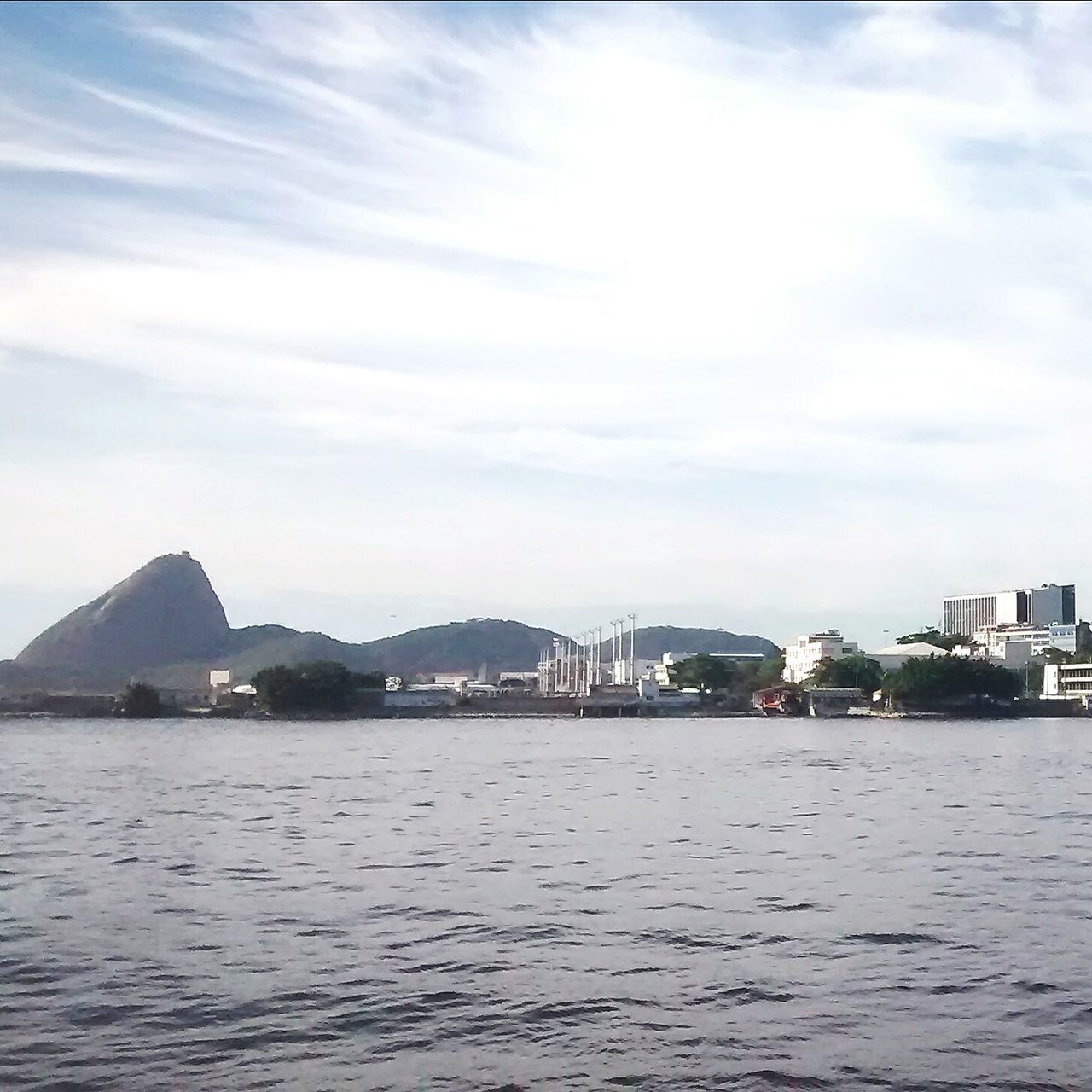 water, waterfront, architecture, sky, building exterior, built structure, sea, mountain, cloud - sky, nautical vessel, rippled, river, scenics, transportation, tranquility, cloud, tranquil scene, nature, beauty in nature, boat