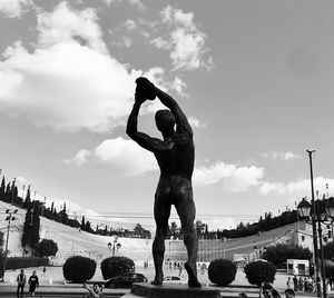 Statue in city against sky