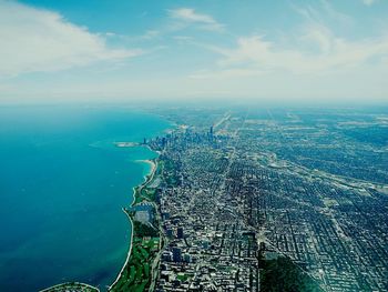 High angle view of cityscape by sea against sky