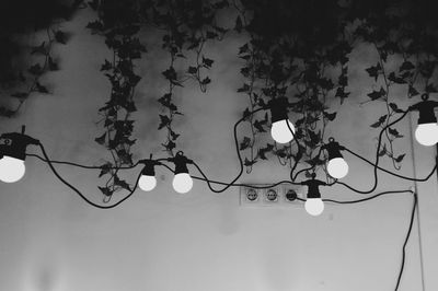 Low angle view of illuminated light bulb against sky