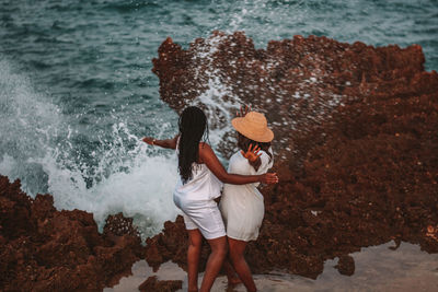 Rear view of woman standing at beach