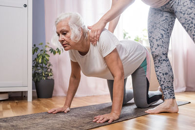 Side view of woman exercising at home