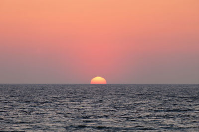 Scenic view of sea against orange sky