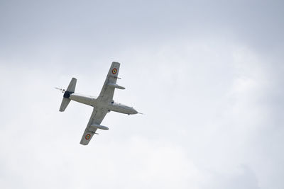 Low angle view of airplane flying against sky