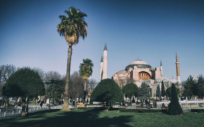 People at temple against clear sky