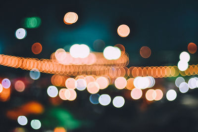 Defocused lights against sky at night