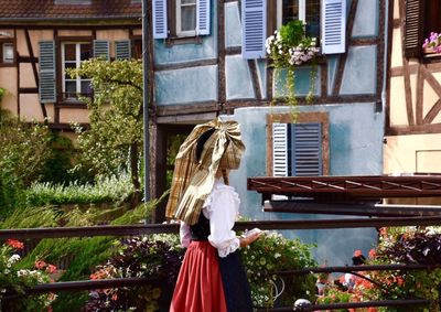 Woman standing by flower tree in city