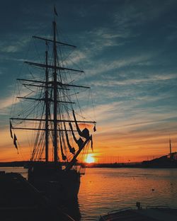 Silhouette ship on sea against sky during sunset