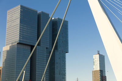 Low angle view of modern buildings against clear blue sky in city