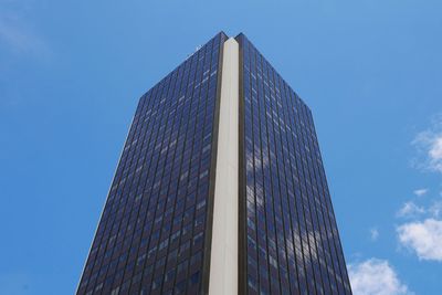 Low angle view of modern building against blue sky