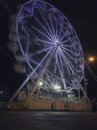 Low angle view of illuminated ferris wheel at night