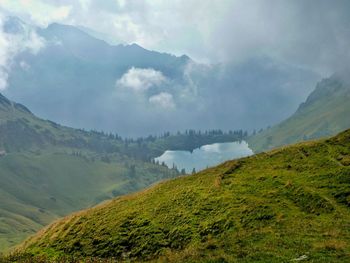 Scenic view of mountains against cloudy sky