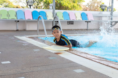 Portrait of boy sitting in swimming pool