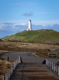 Lighthouse by sea against sky