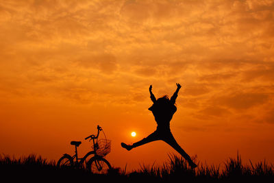 Silhouette of person against orange sky