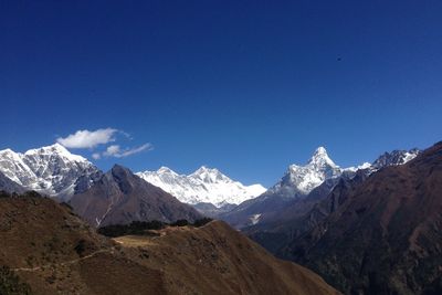 Scenic view of snowcapped mountains against blue sky