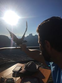 Portrait of man holding sun against sky