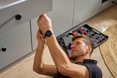 Low section of man using mobile phone in gym